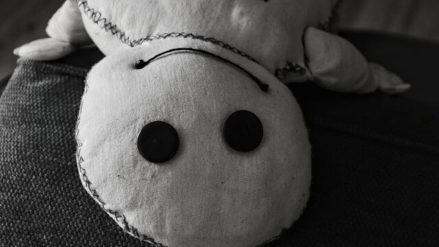 Das Wesen liegt rücklinks lächelnd auf der Sofakante.