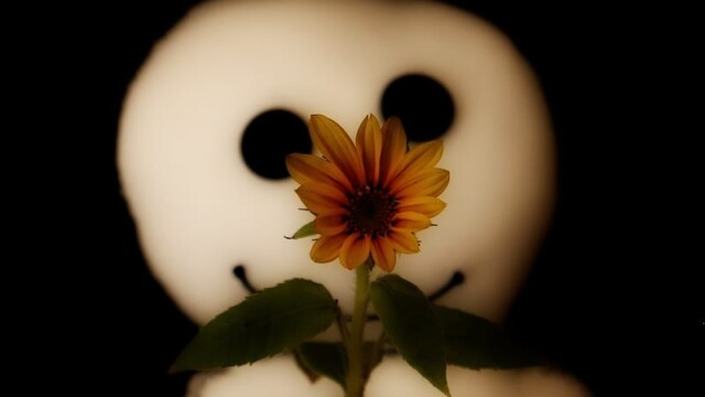 Das Wesen steht im Hintergrund, im Vordergrund eine sehr hübsche Sonnenblume, die aussieht, als wäre sie des Wesens Nase.